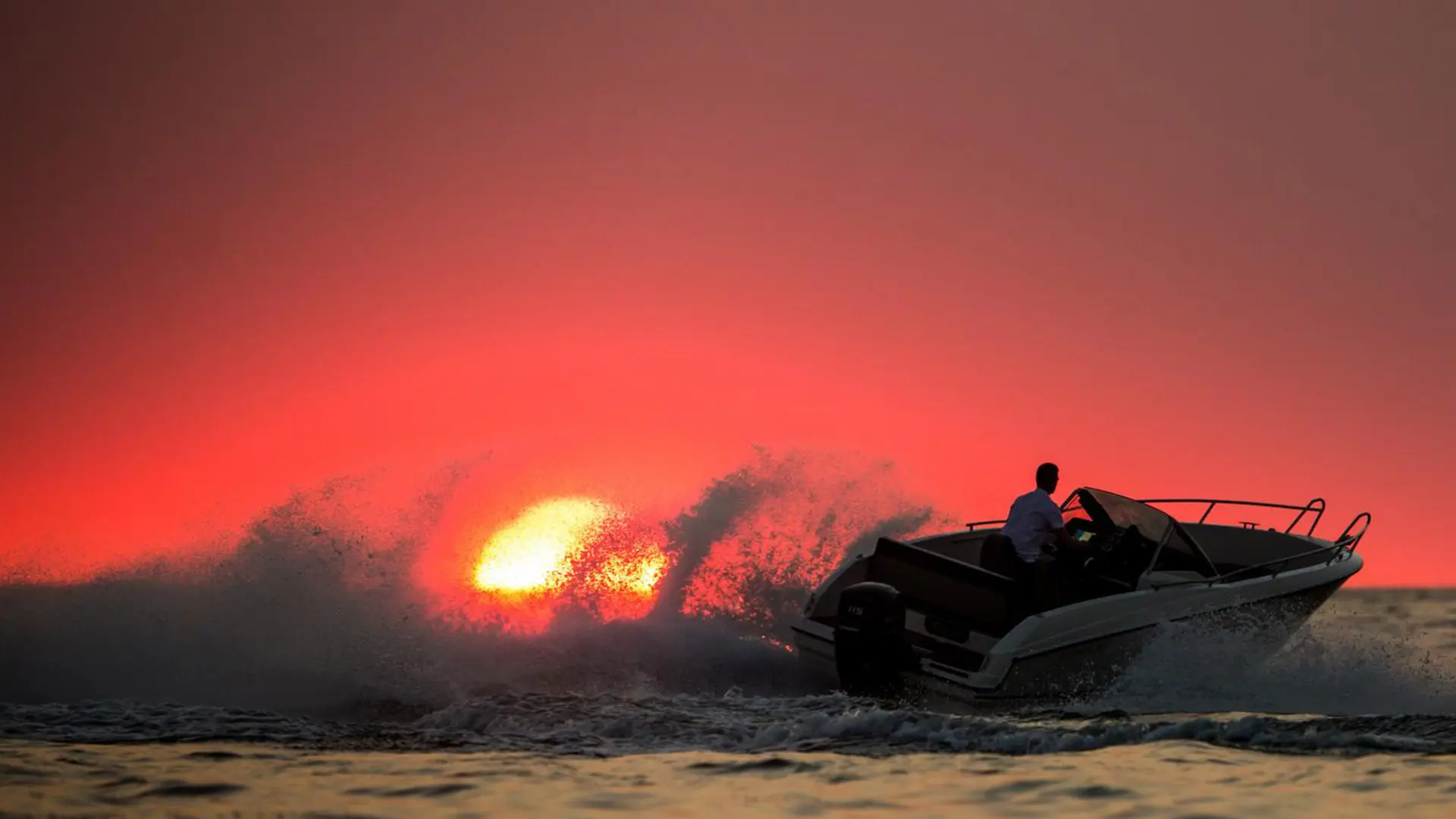 Motorboot im Gegenlicht der untergehenden Sonne