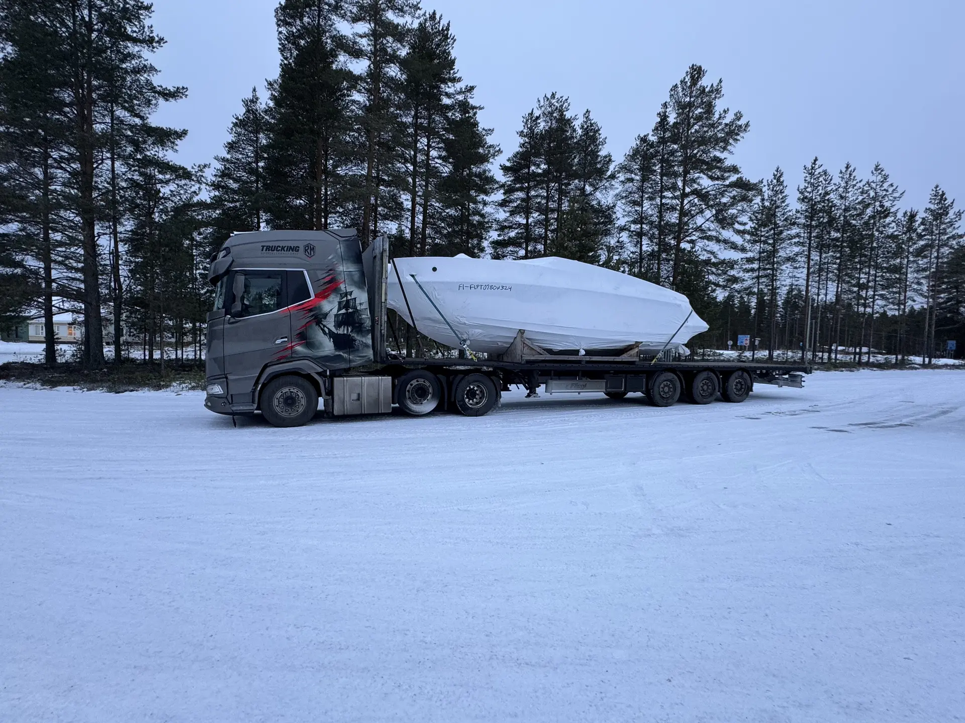 LKW mit verpacktem Boot im Schnee