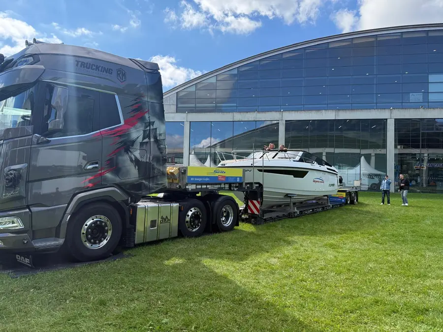 LKW mit Tieflader transportiert Motoryacht