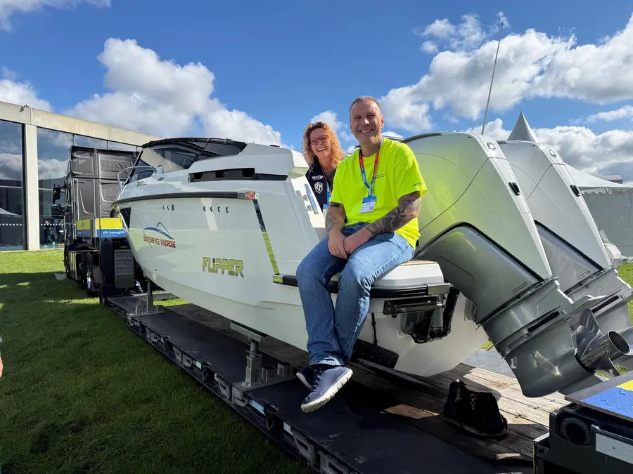 Unser Team mit einem neuen Boot auf dem Tieflader bei der Messe
